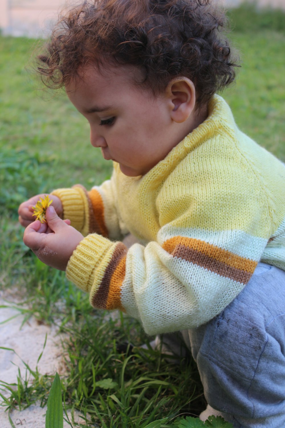 a small child is playing with a flower