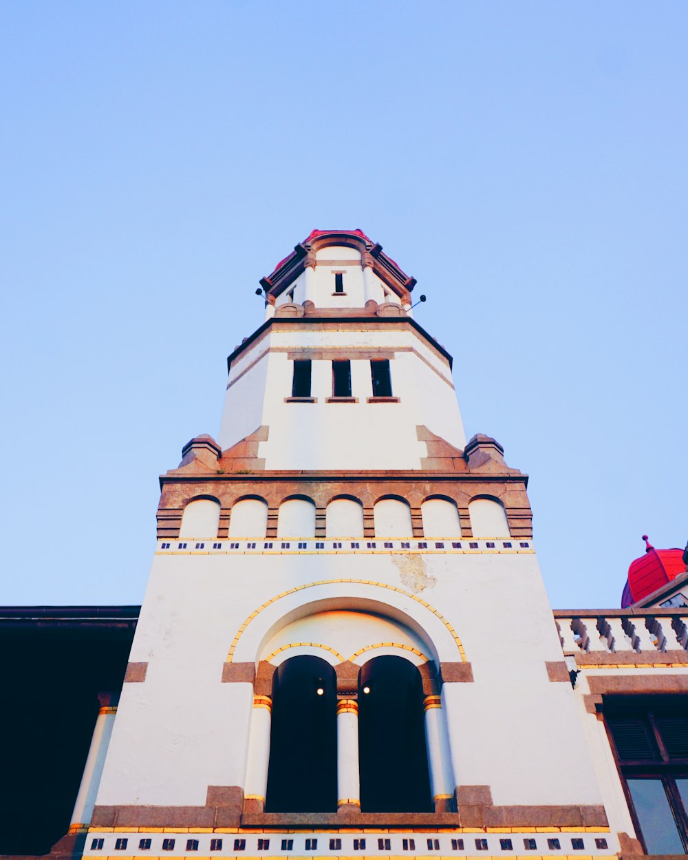 a tall white building with a clock on the top of it