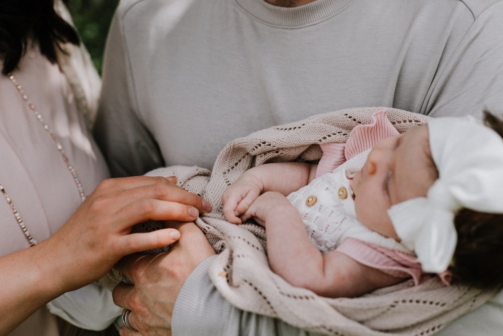 a woman holding a baby wrapped in a blanket