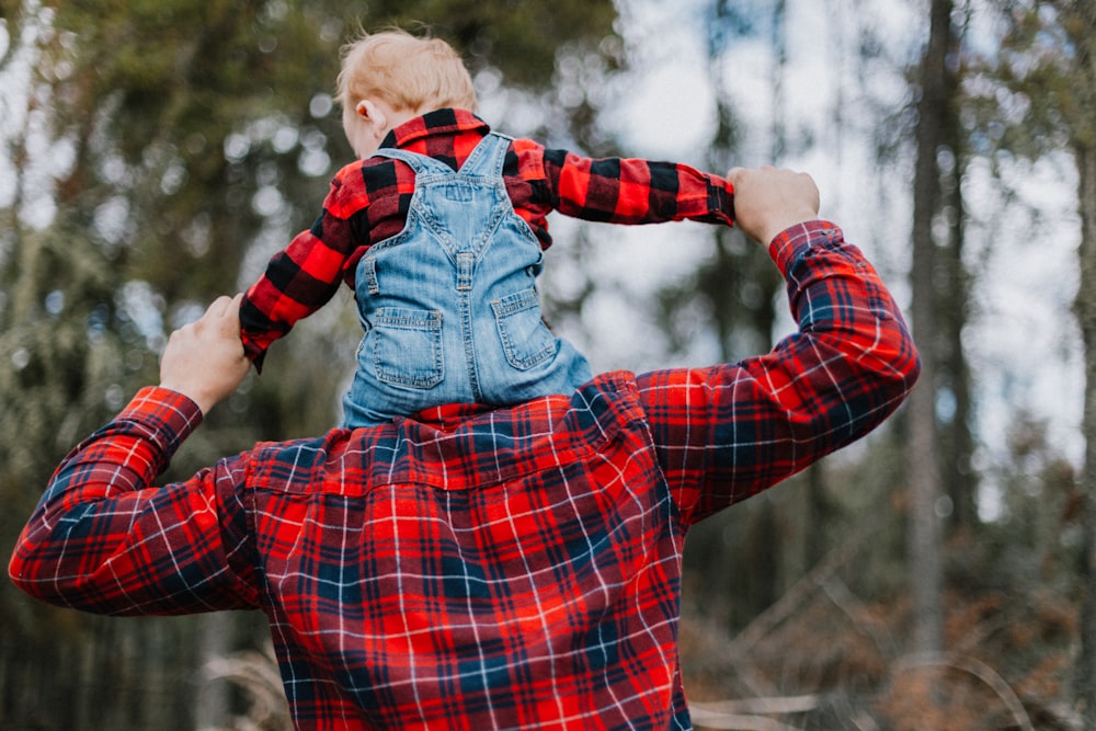 Un hombre sosteniendo a un niño en sus brazos en el bosque