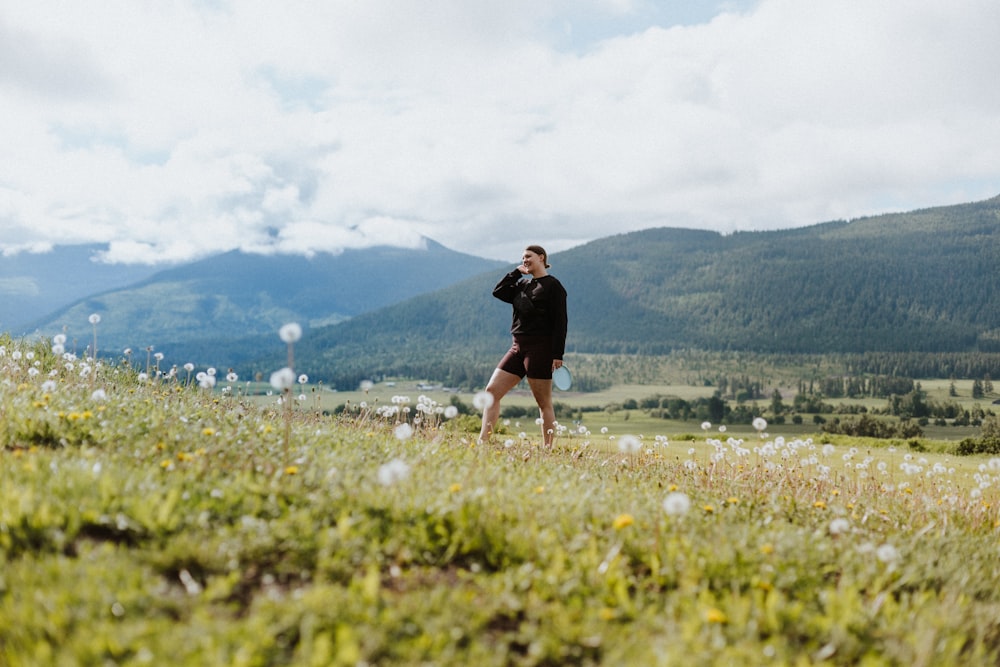 a man standing on top of a lush green hillside