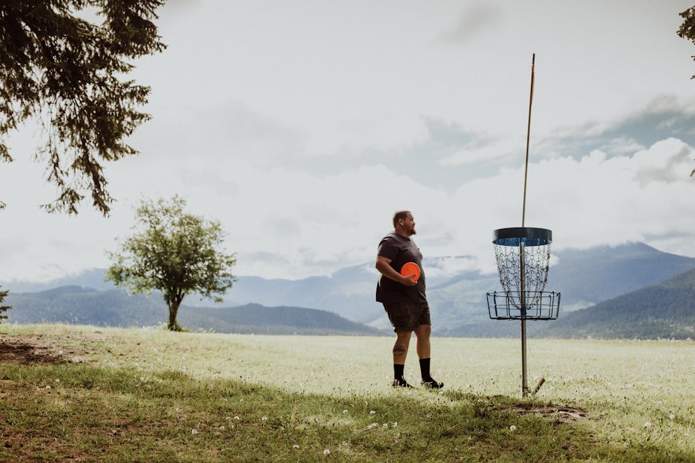 a man holding a frisbee standing in a field