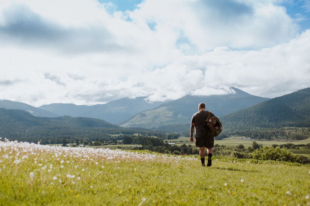 a man with a backpack walking through a field