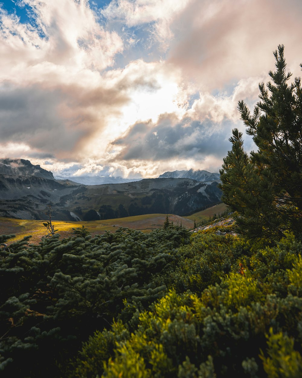 a scenic view of a mountain range with clouds in the sky