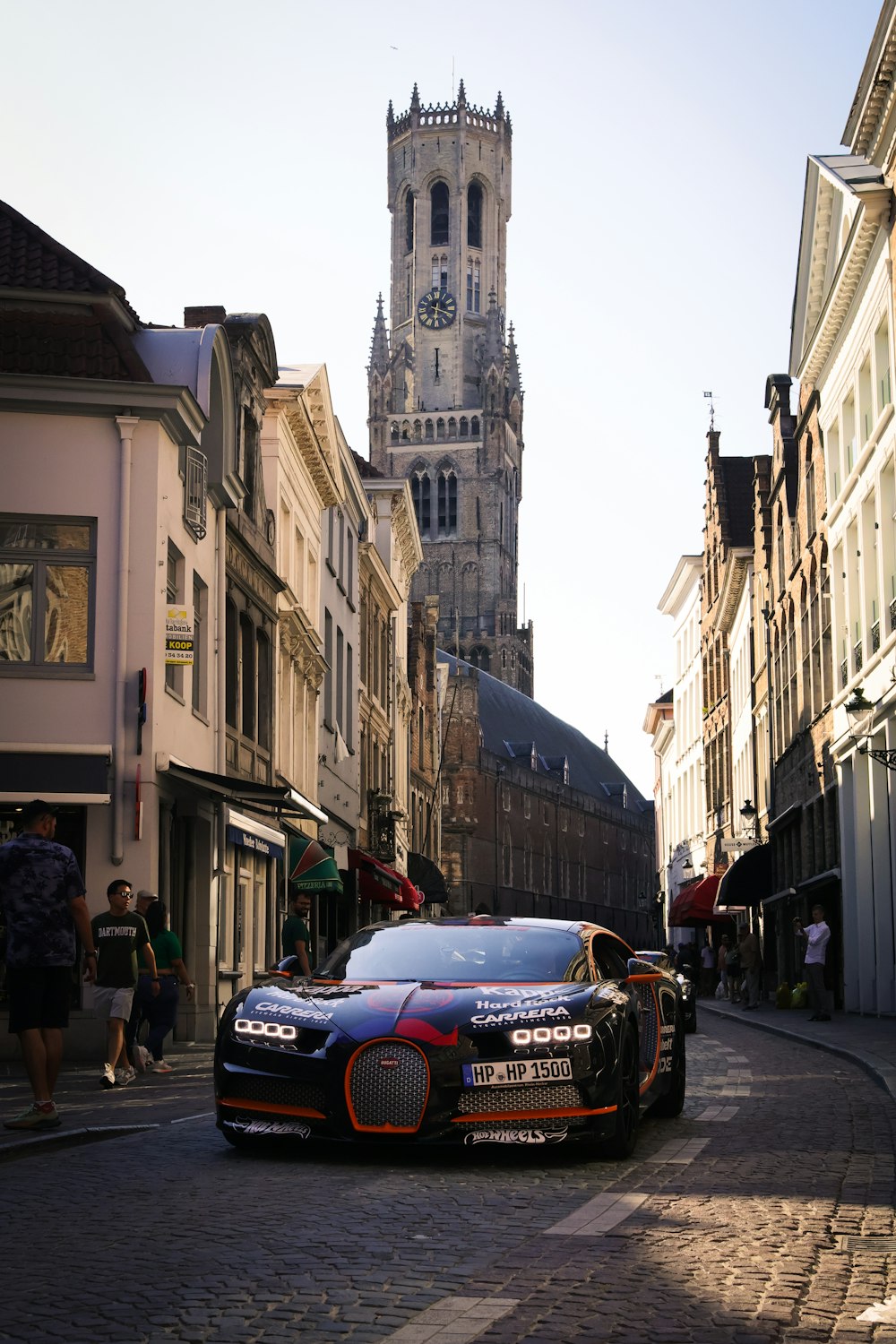 a car parked on the side of a street next to tall buildings