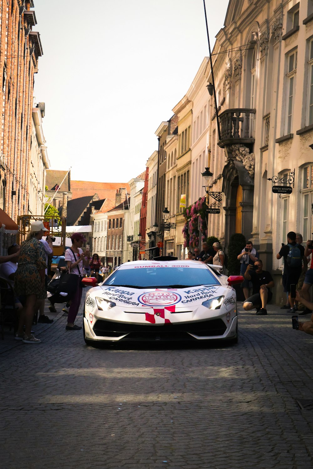 a car driving down a street next to tall buildings