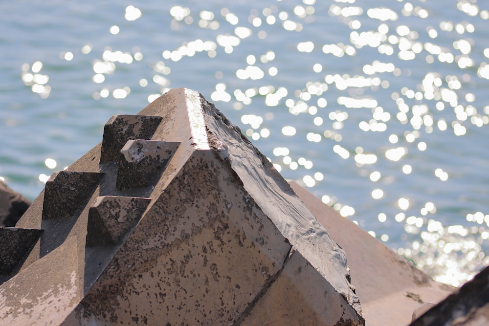 a close up of a stone structure near a body of water