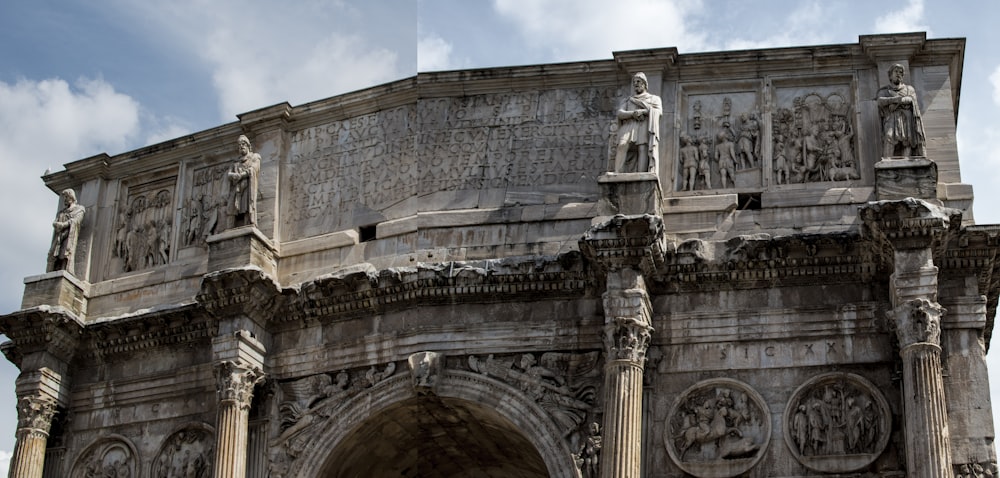 a large stone arch with statues on it