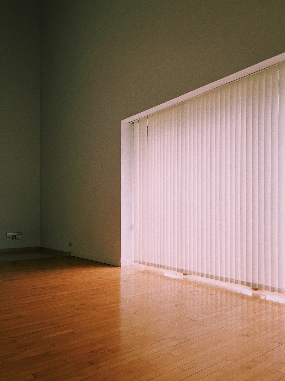 an empty room with a sliding door and hard wood floor