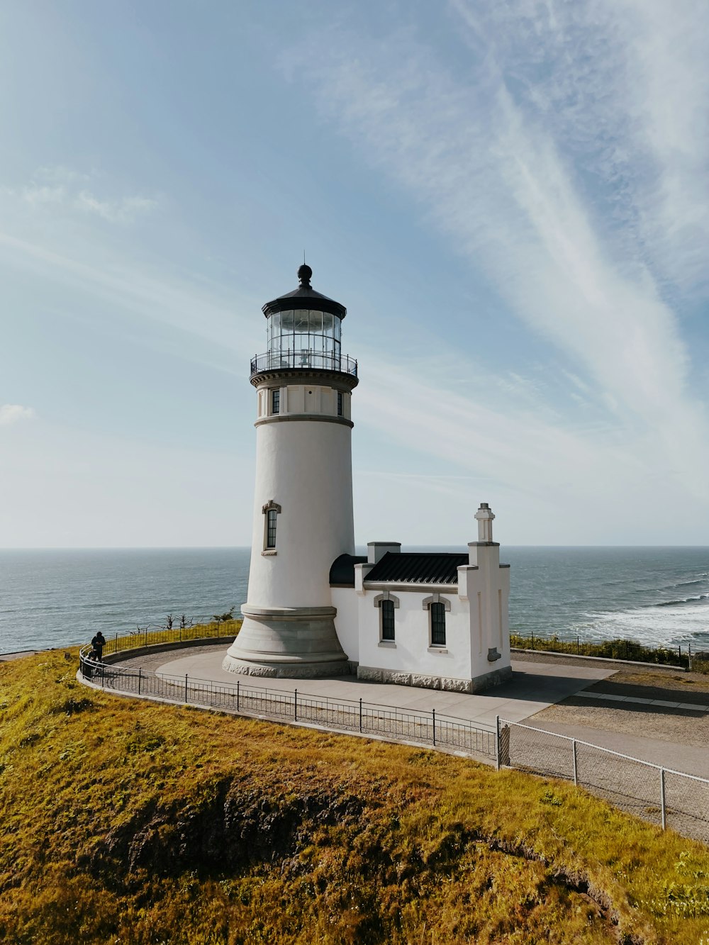 a light house sitting on top of a hill next to the ocean