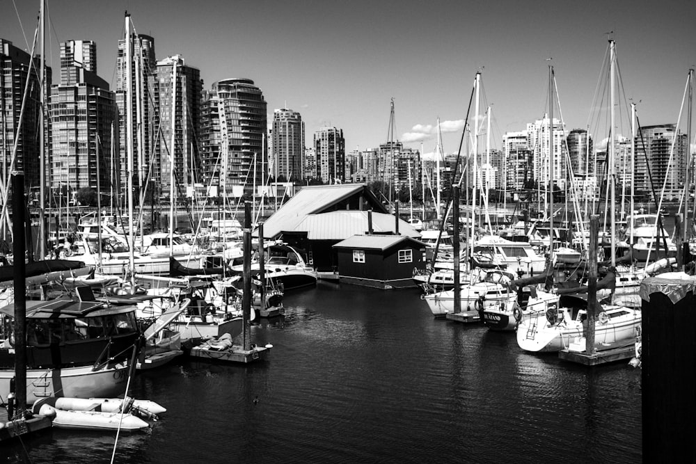 a harbor filled with lots of boats next to tall buildings