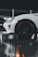 A close-up of a glossy black luxury sports car parked under soft city lights at night.