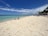 A happy retiree relaxing on a sunny Palawan beach with clear blue waters and palm trees.
