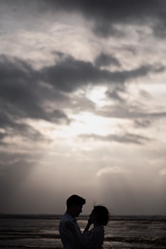 A romantic couple silhouetted against a stormy sky.