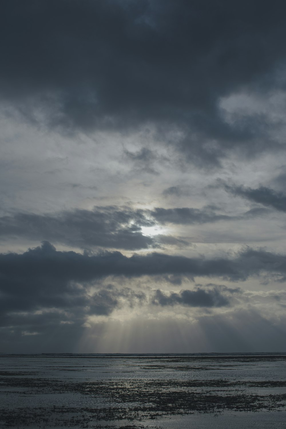 the sun is shining through the clouds over the ocean