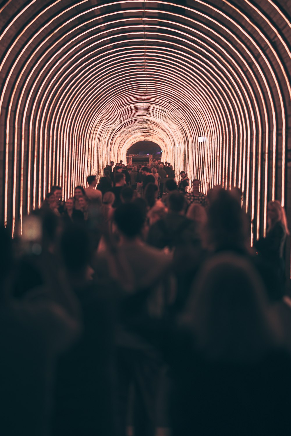 a crowd of people walking through a tunnel