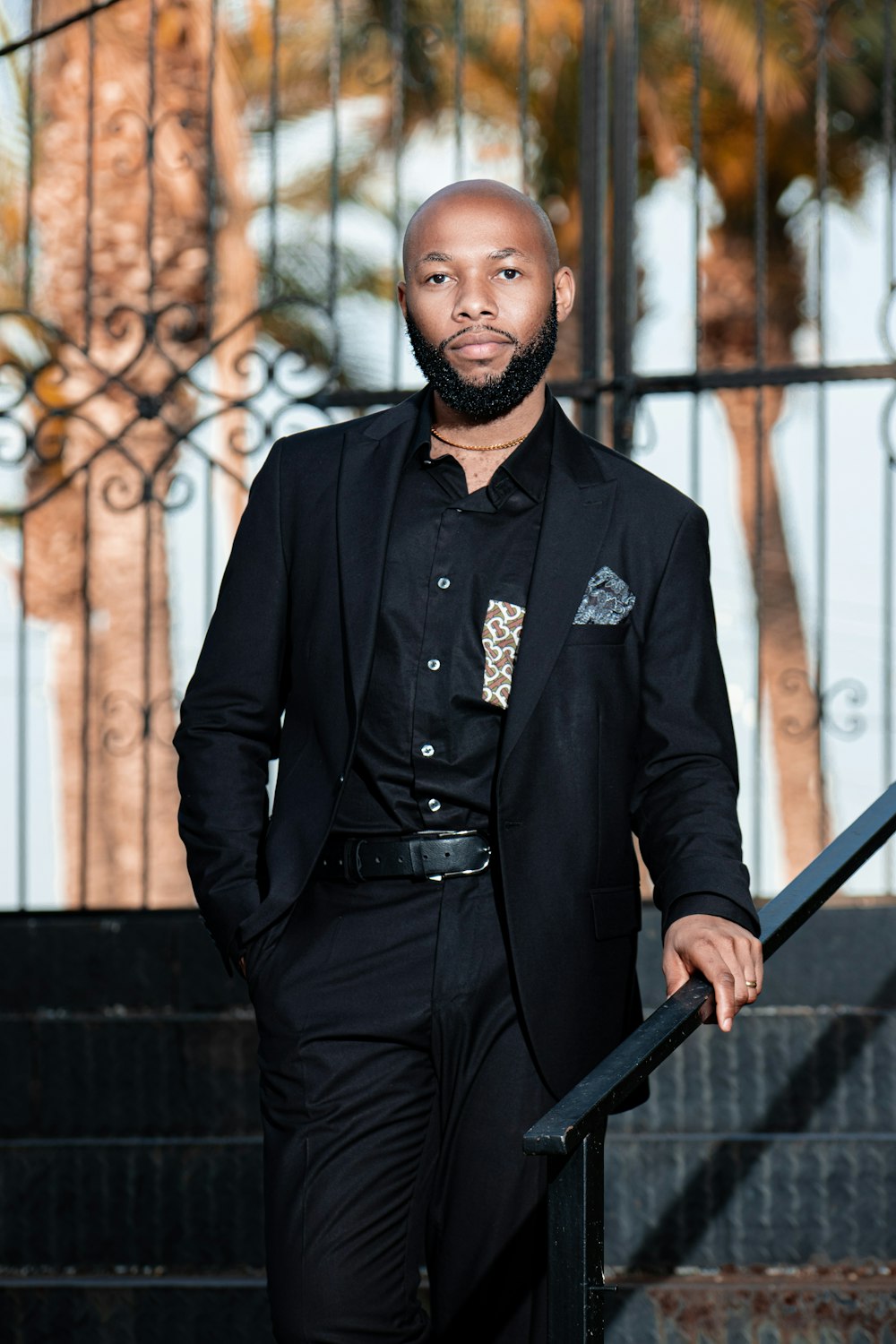 a man in a black suit standing on a stair case