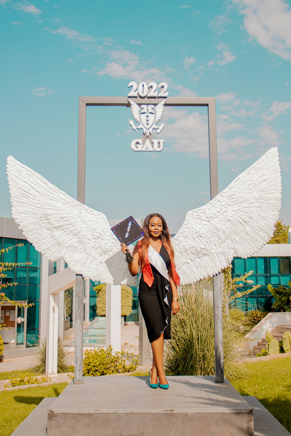 a woman standing in front of a statue of an angel