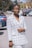 a woman in a white jacket and white pants