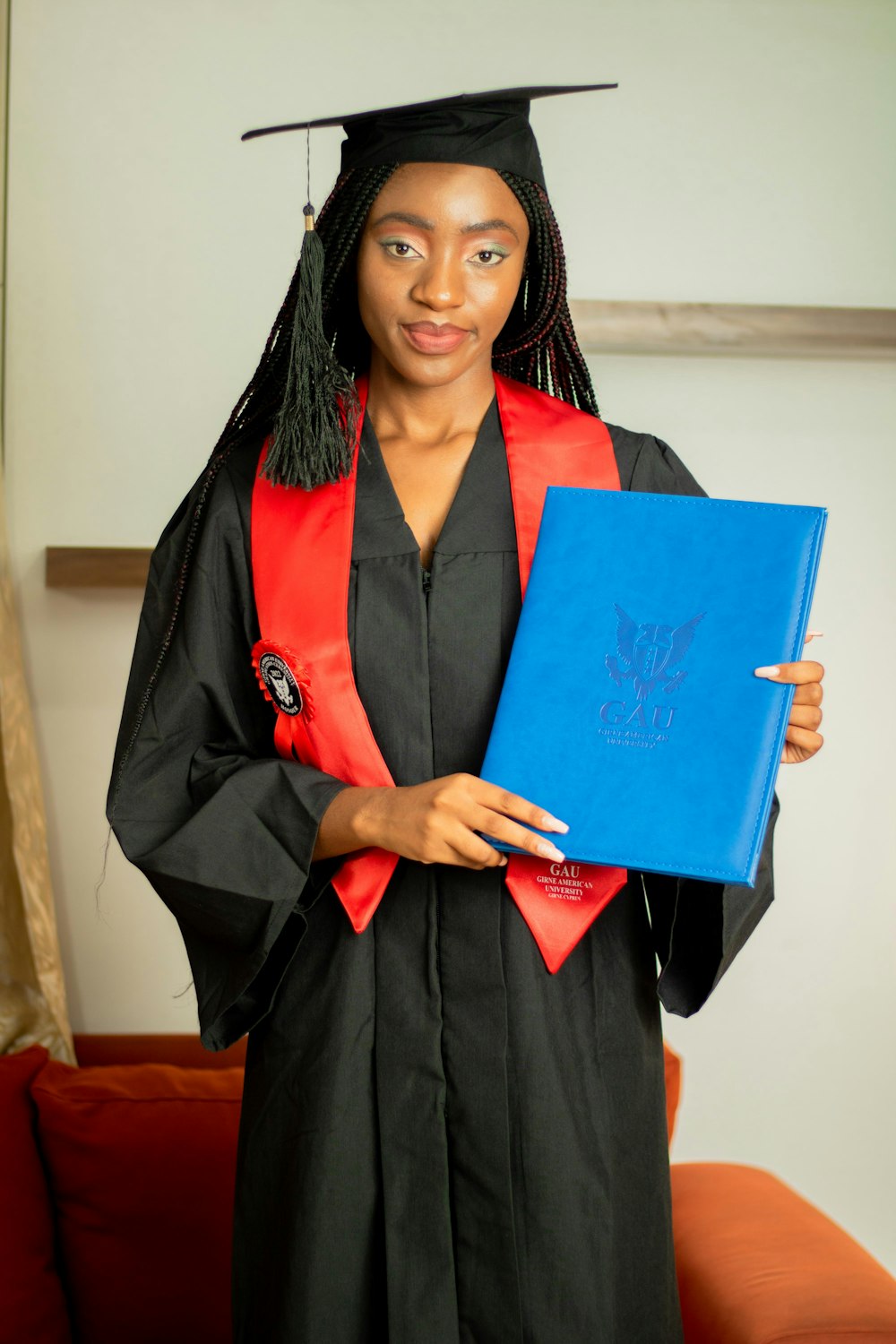 a woman in a graduation gown holding a blue book