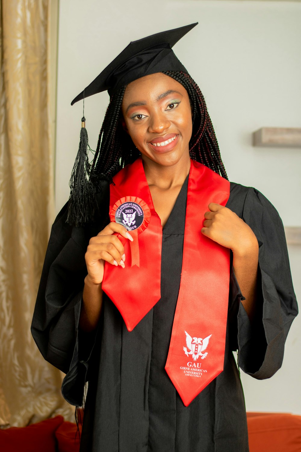 a woman in a graduation gown holding a red tie