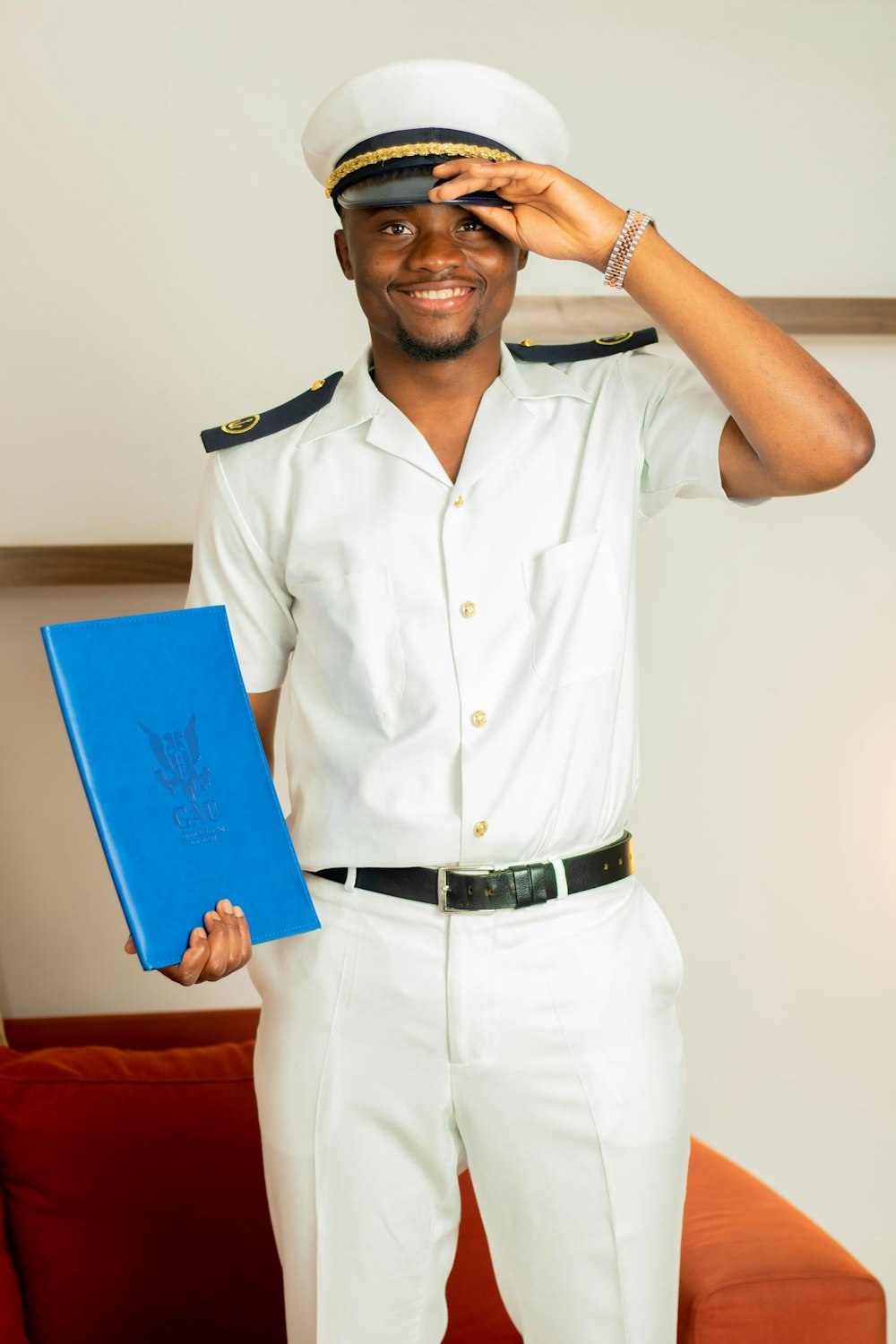a man in a sailor's uniform holding a blue folder
