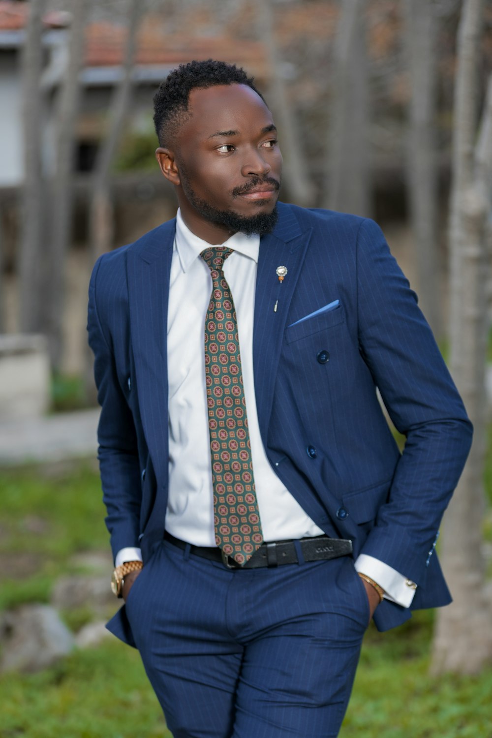 a man in a suit and tie standing in the grass