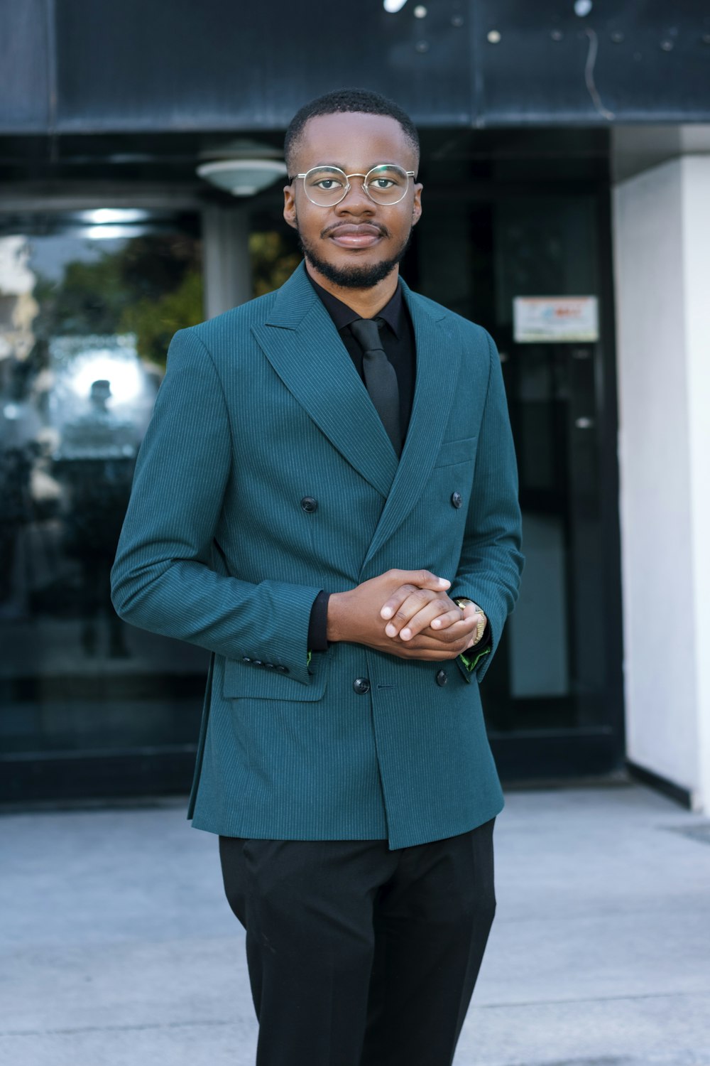 a man in a suit and tie standing in front of a building