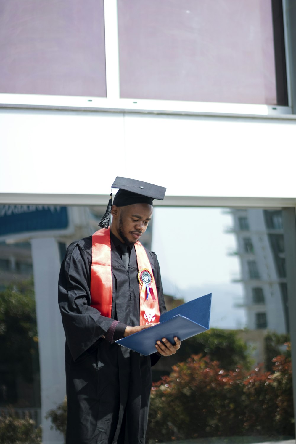 a man in a graduation gown holding a piece of paper