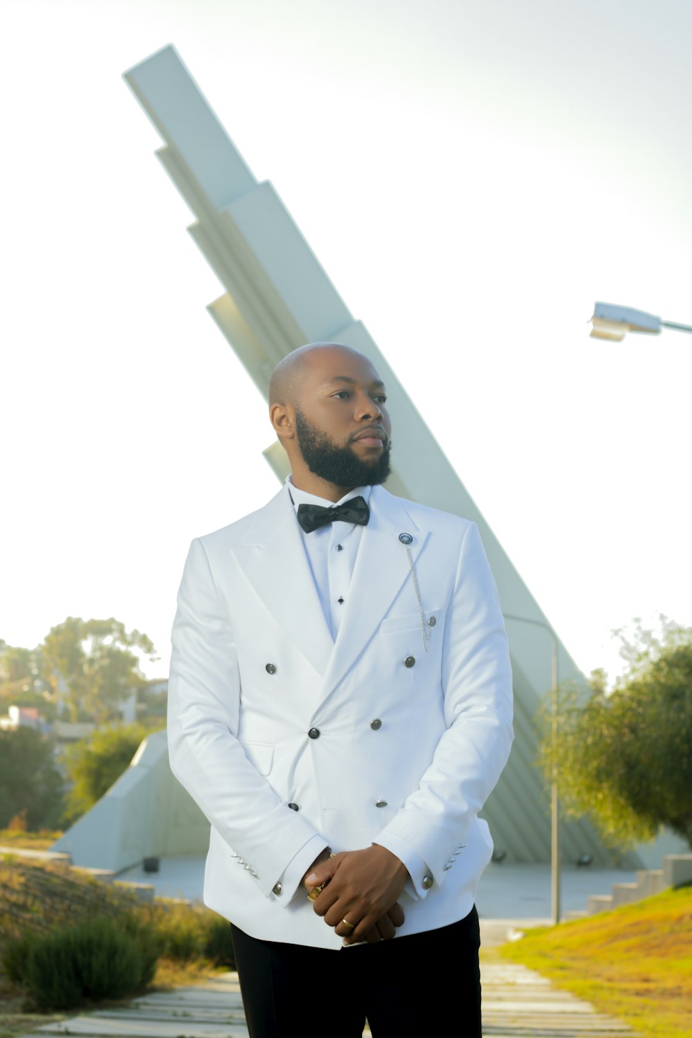 a man wearing a white tuxedo and bow tie