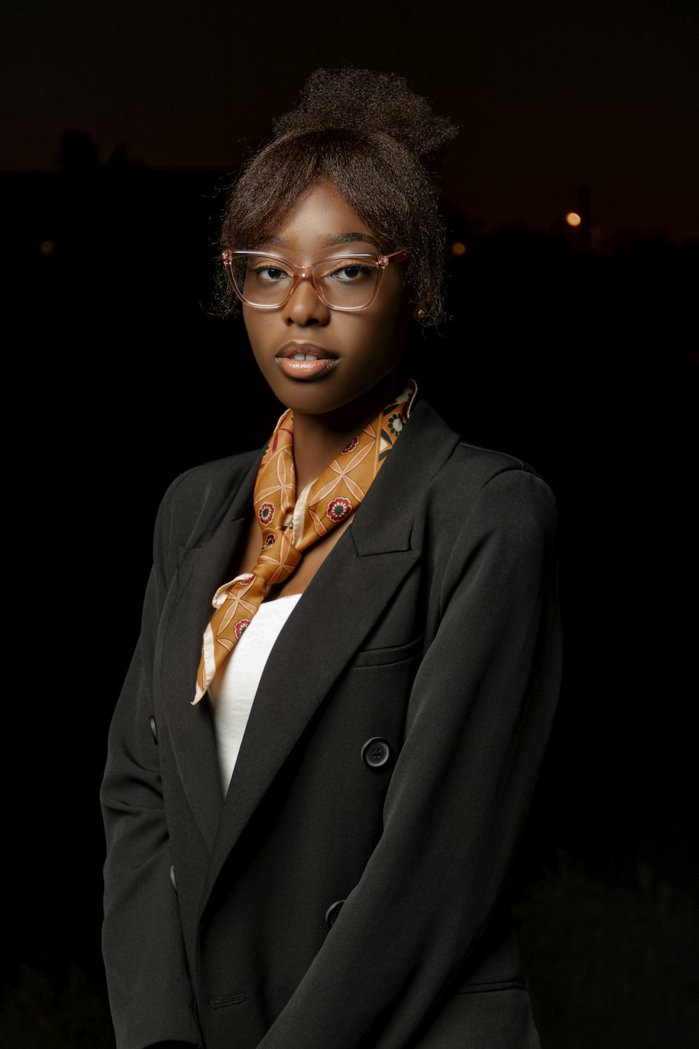 a woman wearing glasses and a black jacket