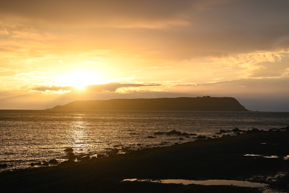 the sun is setting over a body of water