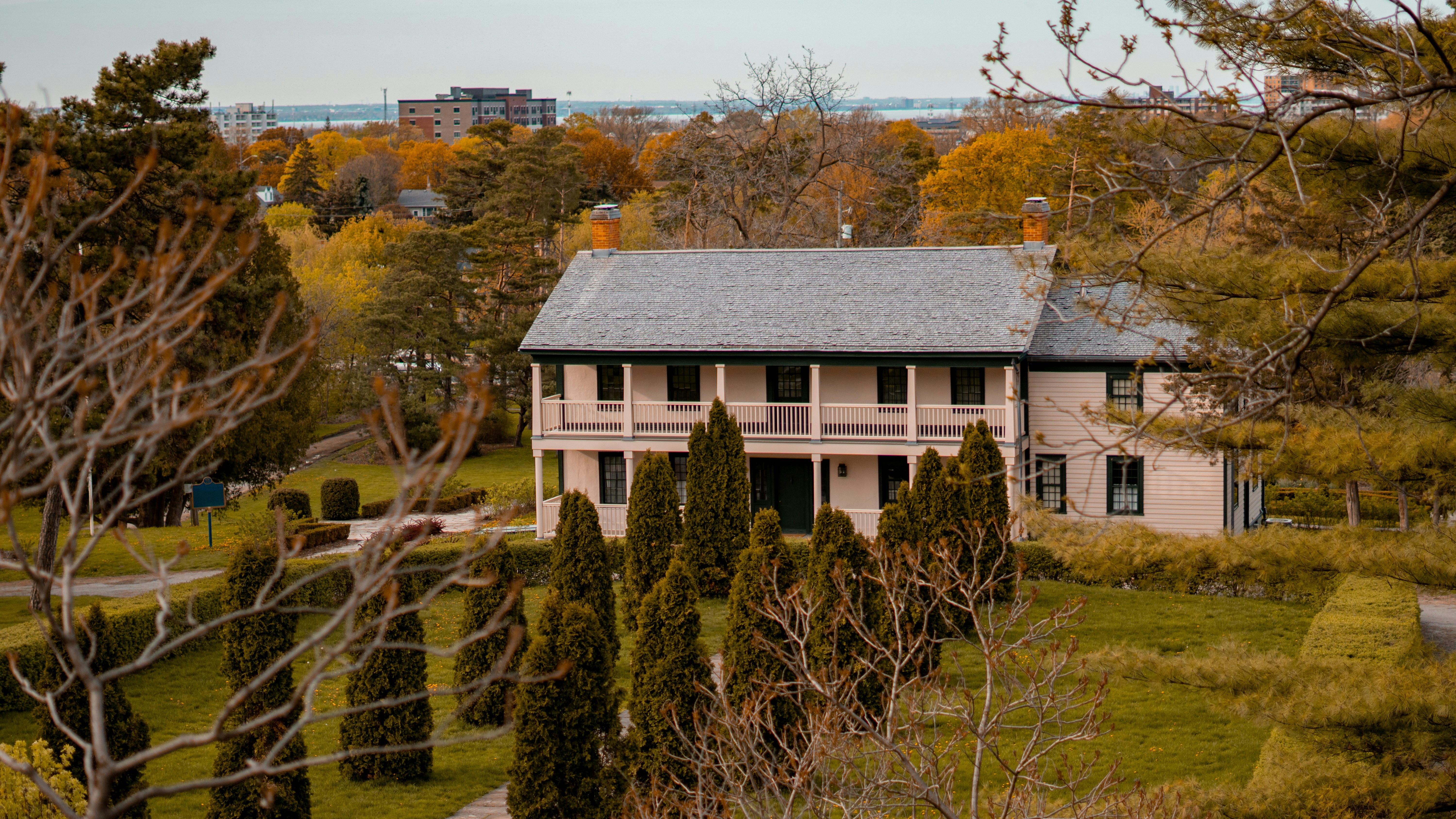 a house in the middle of a field surrounded by trees