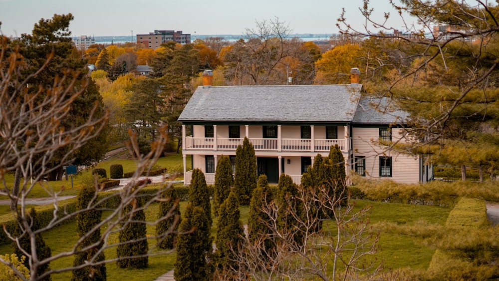 a house in the middle of a field surrounded by trees