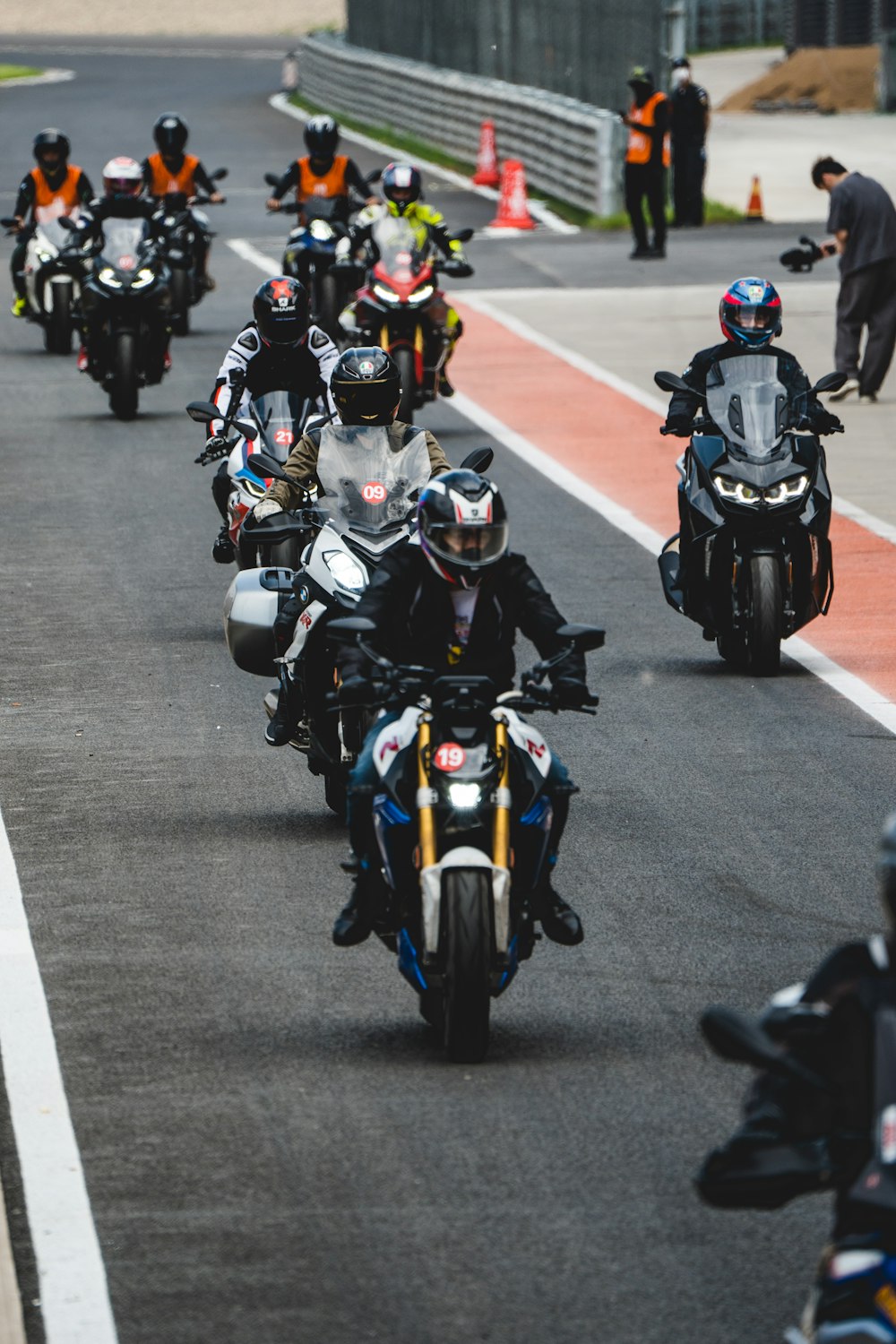 a group of motorcyclists riding down a race track