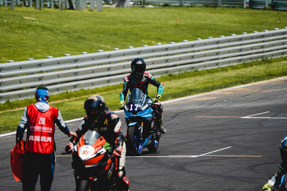 a group of people riding motorcycles on a race track