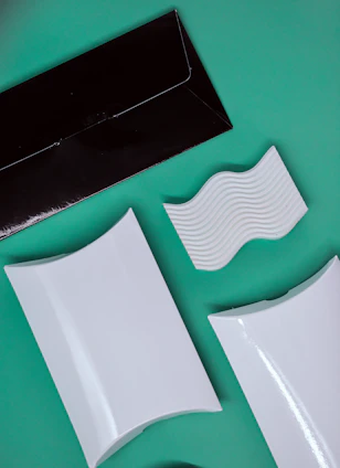 A sleek, modern packaging design workspace with designers collaborating over custom box prototypes.