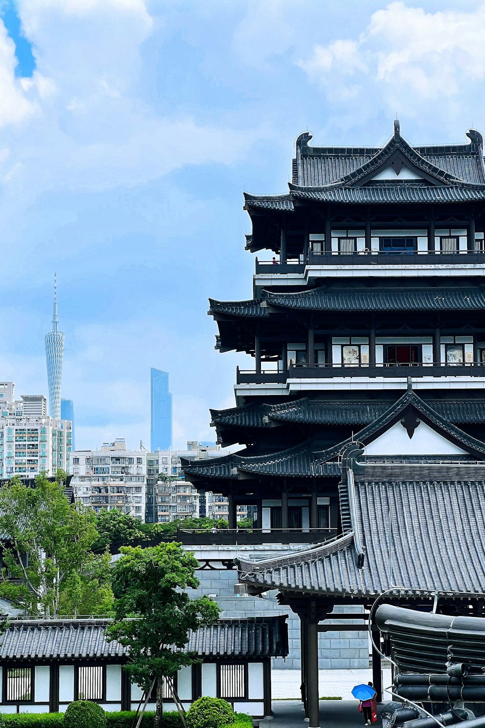 a tall building sitting next to a lush green park