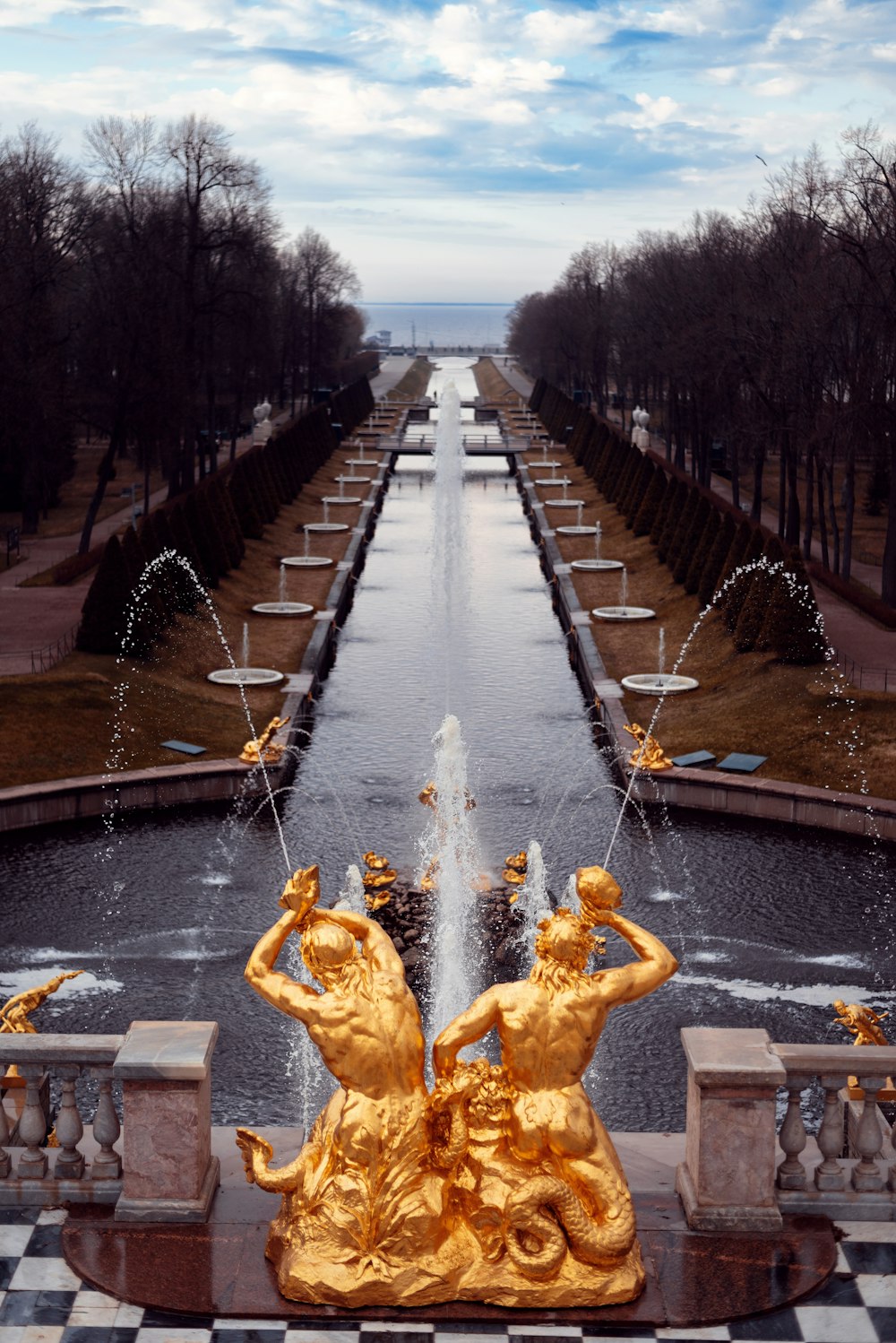 a view of a fountain with two statues in front of it