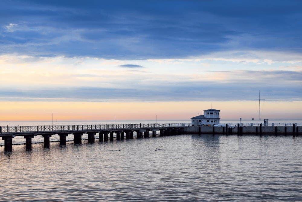 a pier with a light house in the distance