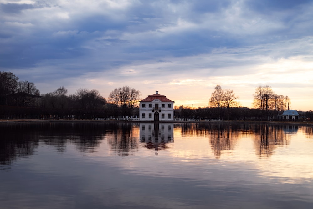 uma casa branca sentada no topo de um lago