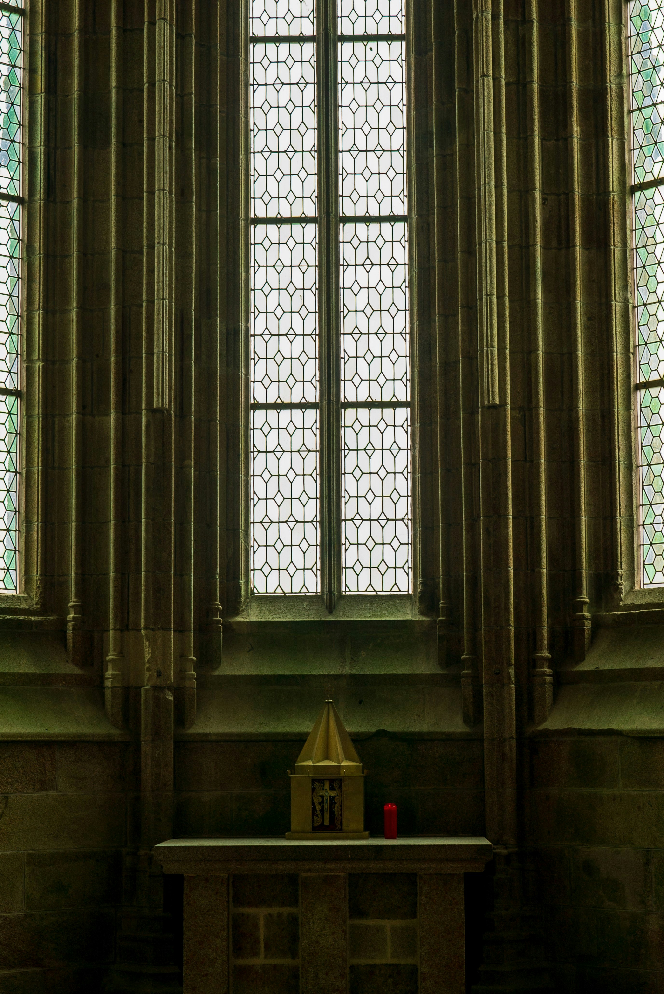 Interior of Saint Thomas More Catholic Church, warm candlelight, golden altar, stained glass, reverent atmosphere