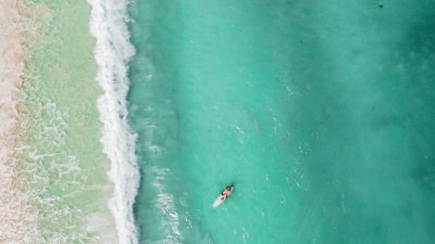 Close-up aerial photo of a paddleboarder gliding on crystal-clear water in Rio das Ostras