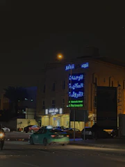 A sleek LED sign illuminating a busy street in the UAE at night.