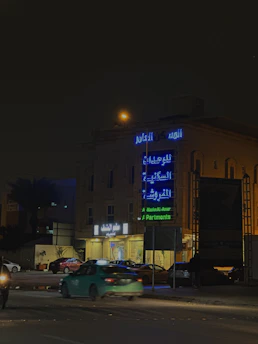 A sleek LED sign illuminating a busy street in the UAE at night.