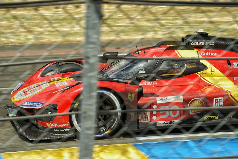 a red race car driving on a race track