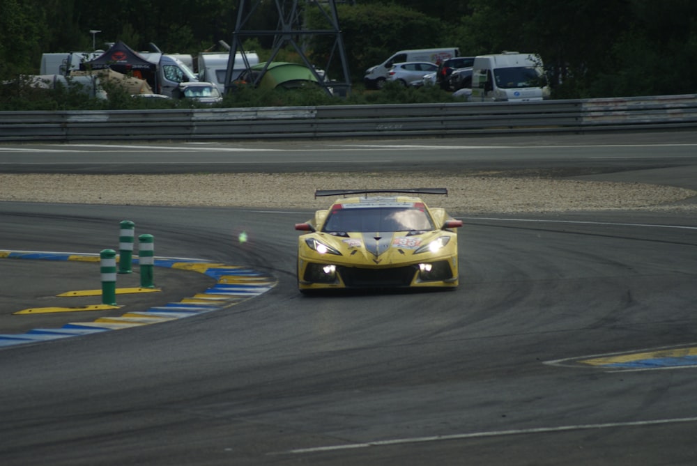 a yellow sports car driving on a race track