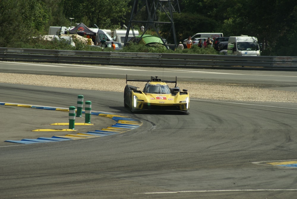 a yellow race car driving on a race track