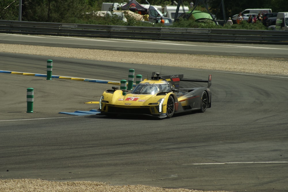 a yellow race car driving down a race track