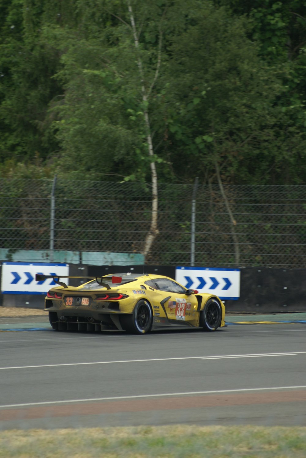 a yellow sports car driving down a race track